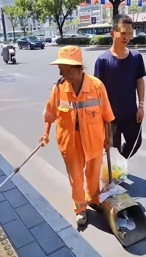 聚创配资 环卫工用绳牵智力障碍儿子扫街，知情人：她拒绝社会捐赠